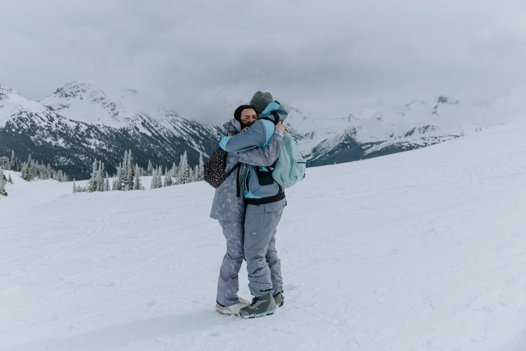 Couple hug after getting engaged on Whistler mountain